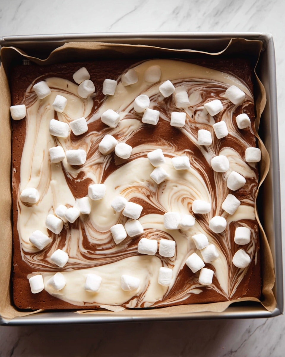 A baking pan lined with parchment paper holds a two-layered dessert with a rich, smooth texture. The base layer is a dark brown chocolate mix, while the top layer is a creamy white swirl that blends into the chocolate, forming a marbled pattern. Scattered uniformly across the surface are small, white, puffy marshmallows, adding texture contrast and visual appeal. The pan sits on a white marbled surface, enhancing the colors of the dessert. photo taken with an iphone --ar 4:5 --v 7
