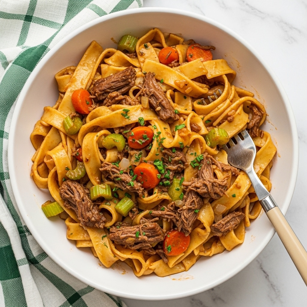 The image shows a white bowl filled with wide, flat pasta noodles mixed with shredded beef and small pieces of orange carrots and light green celery. The pasta is coated with a rich brown sauce giving it a glossy texture, while green herb bits are sprinkled on top for color contrast. A silver fork with a beige handle is placed inside the bowl on the right side, partly lifting some pasta. The bowl sits on a white marbled surface with a green and white checkered cloth partially visible on the left side. Photo taken with an iphone --ar 4:5 --v 7