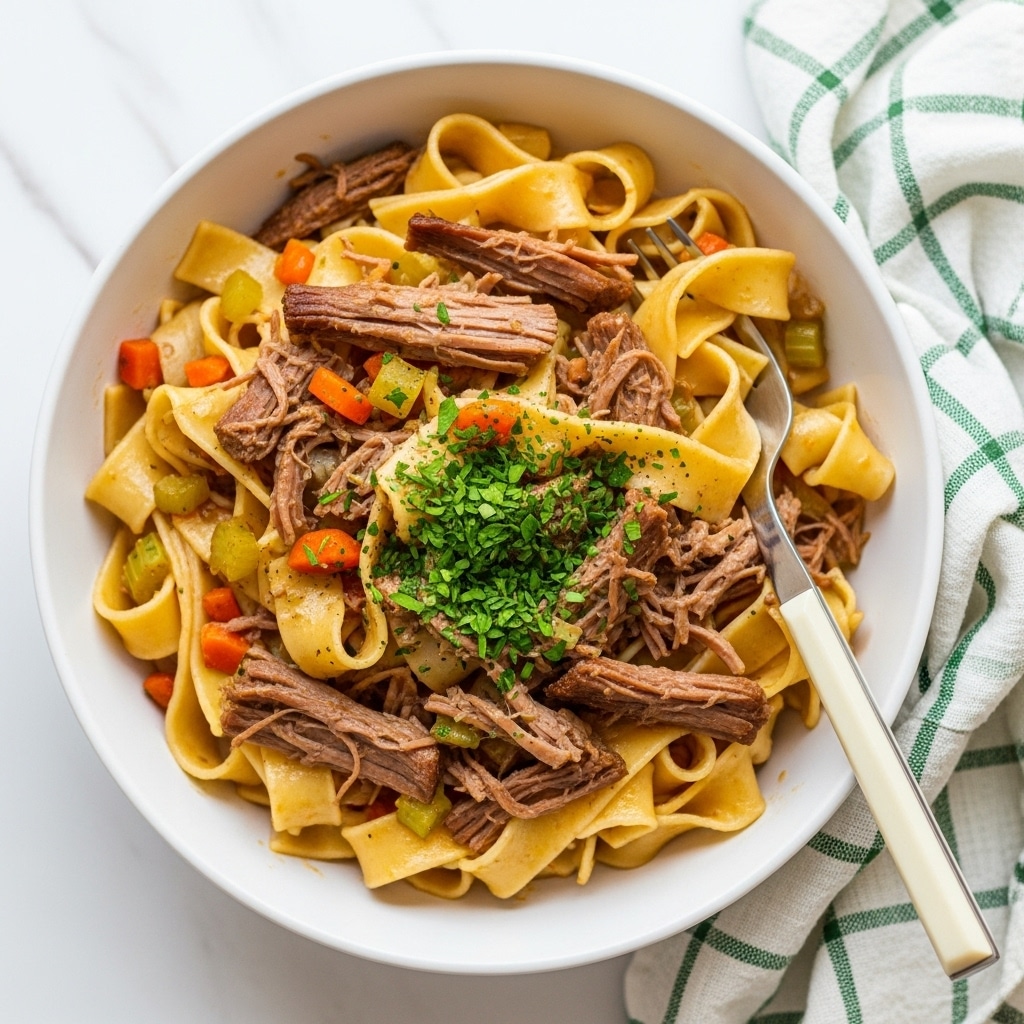The image shows a white bowl filled with wide, flat pasta ribbons mixed with shredded meat and small diced vegetables like carrots and celery. The pasta is a light golden color with a glossy sauce coating it, and the shredded meat is tender and brown, evenly spread throughout the noodles. Bright green herb flakes are sprinkled on top for a fresh touch. A silver fork with a light wooden handle is placed inside the bowl, resting among the pasta. The bowl sits on a white marbled surface with a green and white checkered cloth partially visible on the side. photo taken with an iphone --ar 4:5 --v 7