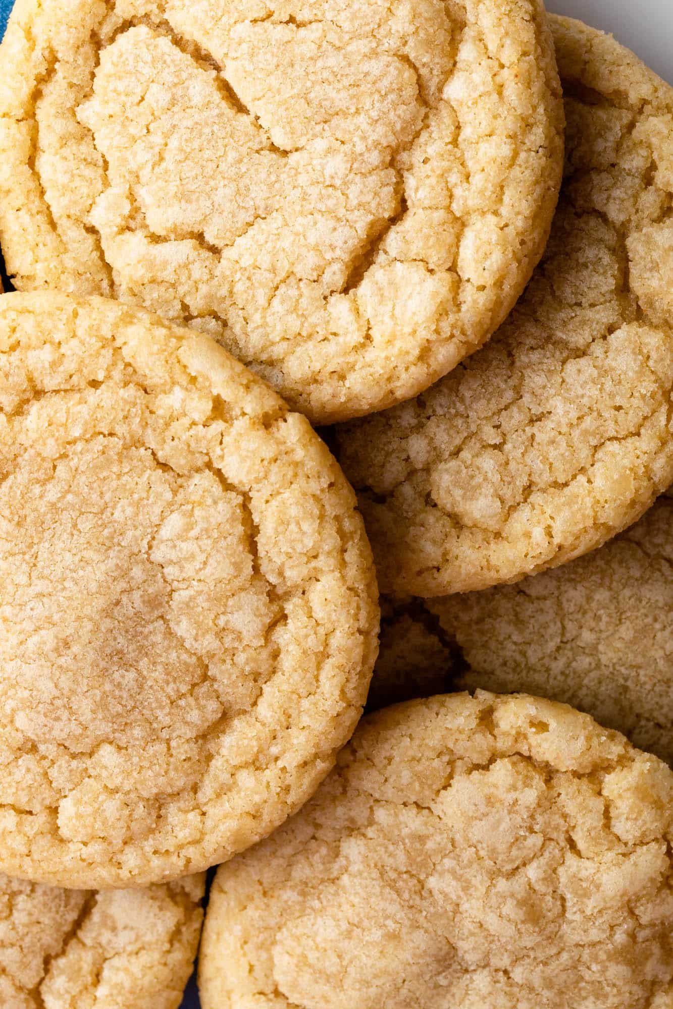 A white plate filled with a mix of golden-brown, crispy chicken pieces and bright green broccoli florets, all coated with visible bits of red pepper flakes, chopped herbs, and small sesame seeds. The chicken pieces have a textured, slightly charred crust with a sprinkling of fresh green herbs, while the broccoli looks tender and vibrant, bursting with a glossy, seasoned coating. A silver fork rests next to the food on the plate, which is set on a white marbled surface. photo taken with an iphone --ar 4:5 --v 7